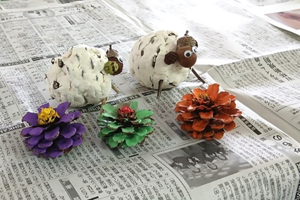 松ぼっくりで作った羊と色鮮やかな花